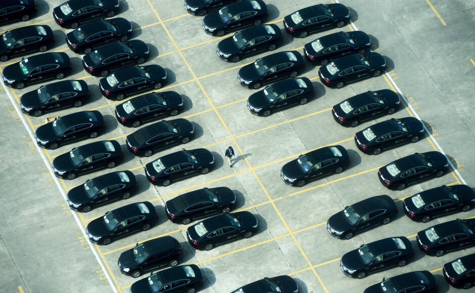 A person walks amongst escort vehicles parked outside the Fortune Global Forum in Guangzhou, China. Speaking to reporters on Tuesday, Trudeau reiterated that a deal with China was not an “overnight process”. AP Justin Trudeau in China: Canada prime minister says he will keep exploring trade deal with Beijing