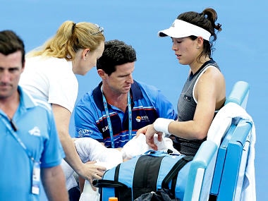 Garbine Muguruza of Spain is treated by medical staff during her match against Aleksandra Krunic of Serbia at the Brisbane International tennis tournament in Brisbane, Australia, Tuesday, Jan. 2, 2018. Muguruza fell to the court behind the baseline in the third set before retiring from her opening match. (AP Photo/Tertius Pickard)