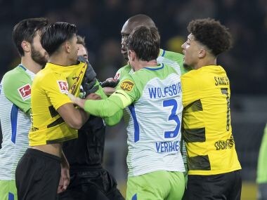 Wolfsburg and Dortmund's players face off after a tackle on Sunday. AP