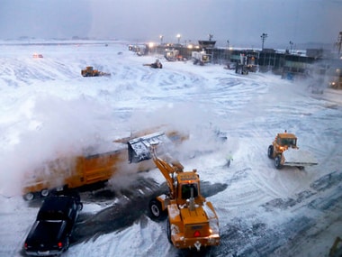 ront loaders dump snow into a melter to clear the runways at New York's La Guardia airport. AP