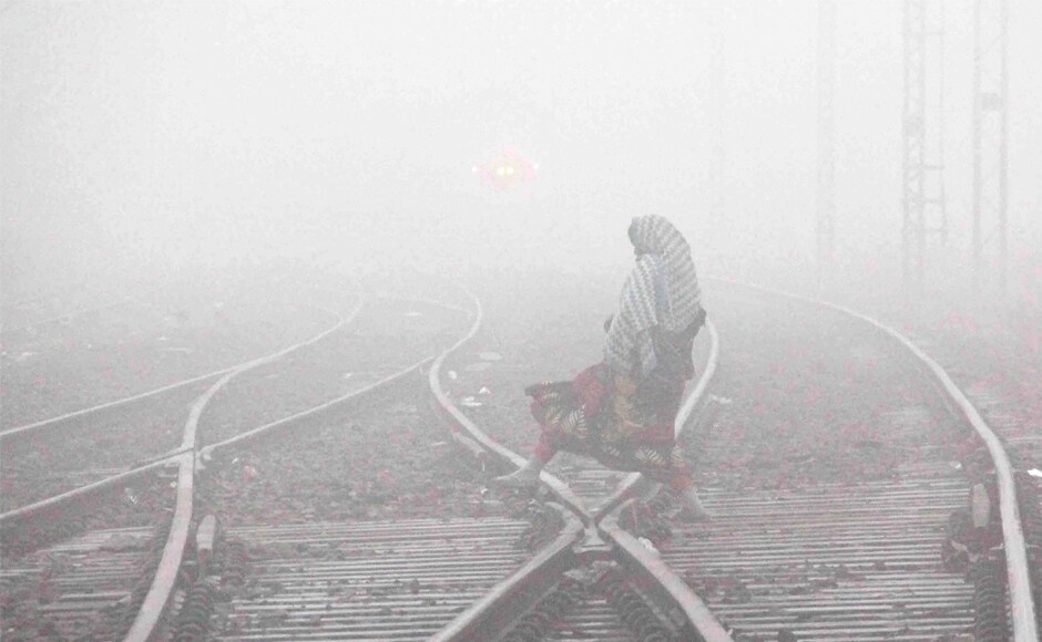 A woman crosses the railway tracks during cold and foggy morning, in Allahabad, Uttar Pradesh on Wednesday. Along with with dense fog, temperatures decreased across Uttar Pradesh, Punjab, Haryana, and parts of Madhya Pradesh. PTI Heavy fog disrupts normal life in Uttar Pradesh, Punjab, Haryana: Cold wave intensifies in several parts of India