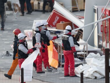 Firefighters assess the damage to a food stall that was blown over by the wind. Reuters
