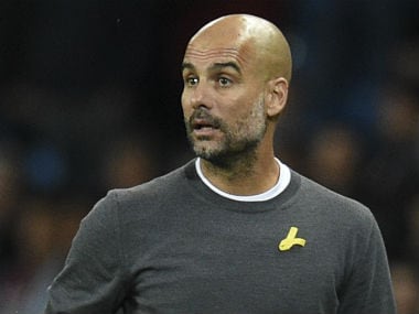Manchester City's Spanish manager Pep Guardiola watches from the touchline wearing a yellow ribbon, a symbol used by Catalan separatists in Spain. AFP