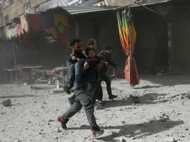 A man runs as he holds a girl after an airstrike in the besieged town of Douma in eastern Ghouta in Damascus, Syria. Reuters