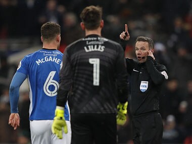 Referee Paul Tierney (R) listens to VAR decision on Tottenham Hotspur's Argentinian midfielder Erik Lamela's goal which is disallowed during the English FA Cup 5th round replay football match between Tottenham Hotspur and Rochdale at Wembley Stadium in London, on February 28, 2018. / AFP PHOTO / Adrian DENNIS / RESTRICTED TO EDITORIAL USE. No use with unauthorized audio, video, data, fixture lists, club/league logos or 'live' services. Online in-match use limited to 75 images, no video emulation. No use in betting, games or single club/league/player publications. /