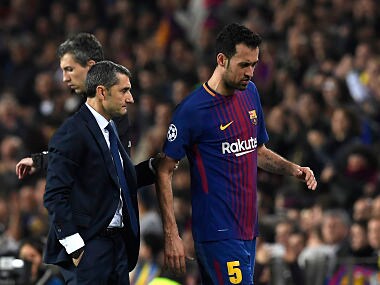 Barcelona's Spanish midfielder Sergio Busquets (R) walks with Barcelona's Spanish coach Ernesto Valverde as he is substituted during the UEFA Champions League round of sixteen second leg football match between FC Barcelona and Chelsea FC at the Camp Nou stadium in Barcelona on March 14, 2018. / AFP PHOTO / LLUIS GENE