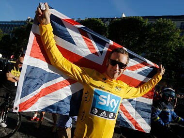 FILE - In this Sunday, July 22, 2012 file photo, Bradley Wiggins, winner of the 2012 Tour de France cycling race, holds the Union flag during the team parade of the the Tour de France cycling race in Paris, France. A British parliamentary committee says in a doping investigation report that Bradley Wiggins used a banned powerful corticosteroid to enhance his performance and not for medical reasons while winning the Tour de France in 2012. The report accuses Team Sky of crossing an “ethical line” after preaching zero tolerance. Team Sky criticized “the anonymous and potentially malicious claim” by members of parliament. (AP Photo/Laurent Cipriani, File)