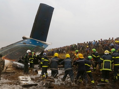 Rescuers work amid the debris after the plane crashed at the airport in Kathmandu. AP