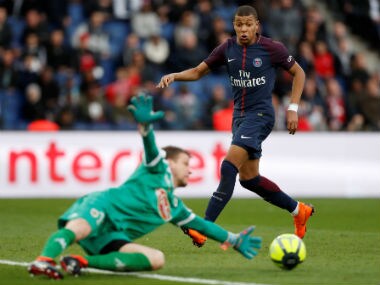 Angers' Ludovic Butelle makes a save as Paris Saint-Germain's Kylian Mbappe looks on. Reuters