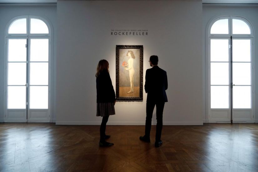 Christie's employees stand next to 'Fillette a la corbeille fleurie' by Pablo Picasso from the collection of Peggy and David Rockefeller during a sale preview at Christie's auction house in Paris, France March 13, 2018. REUTERS/Gonzalo Fuentes
