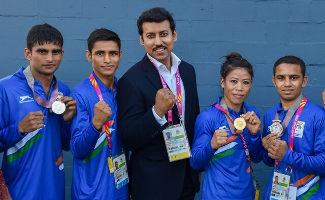 Union Sports Minister Rajyavardhan Singh Rathore poses with medal winners MC Mary Kom, Gaurav Solanki, Manish Kaushik and Amit at the Commonwealth Games 2018. PTI Union Sports Minister Rajyavardhan Singh Rathore poses with medal winners MC Mary Kom, Gaurav Solanki, Manish Kaushik and Amit at the Commonwealth Games 2018. PTI