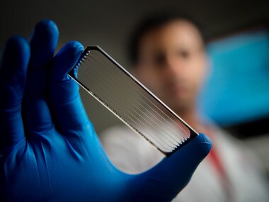 A scientist holds a flow cell used for genomic sequencing of pediatric cancers. Image: St. Jude Children’s Research Hospital.