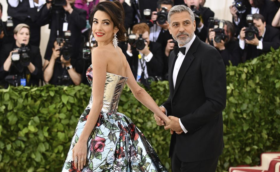 George Clooney (R) and his wife, Amal, were among the first to arrive at Monday's party. Amal was wearing a metallic Richard Quinn gown with train. Photo by Charles Sykes/Invision/AP George Clooney (R) and his wife, Amal, were among the first to arrive at Monday's party. Amal was wearing a metallic Richard Quinn gown with train. Photo by Charles Sykes/Invision/AP