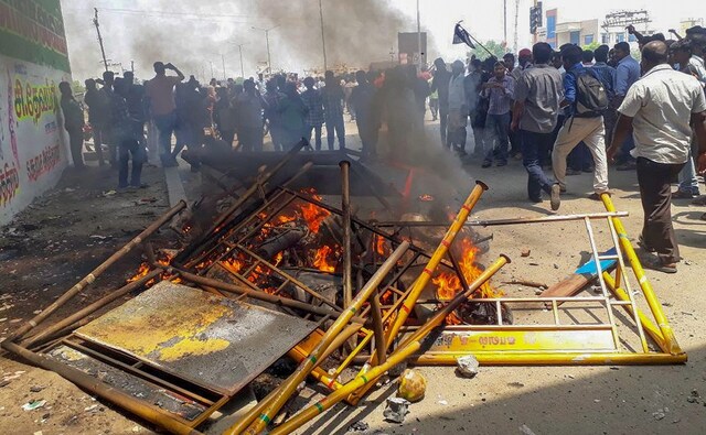 Agitators march through the streets next to the burning barricades. Ten people, including two women, were killed when police opened fire on rampaging protestors. PTI Agitators march through the streets next to the burning barricades. Ten people, including two women, were killed when police opened fire on rampaging protestors. PTI