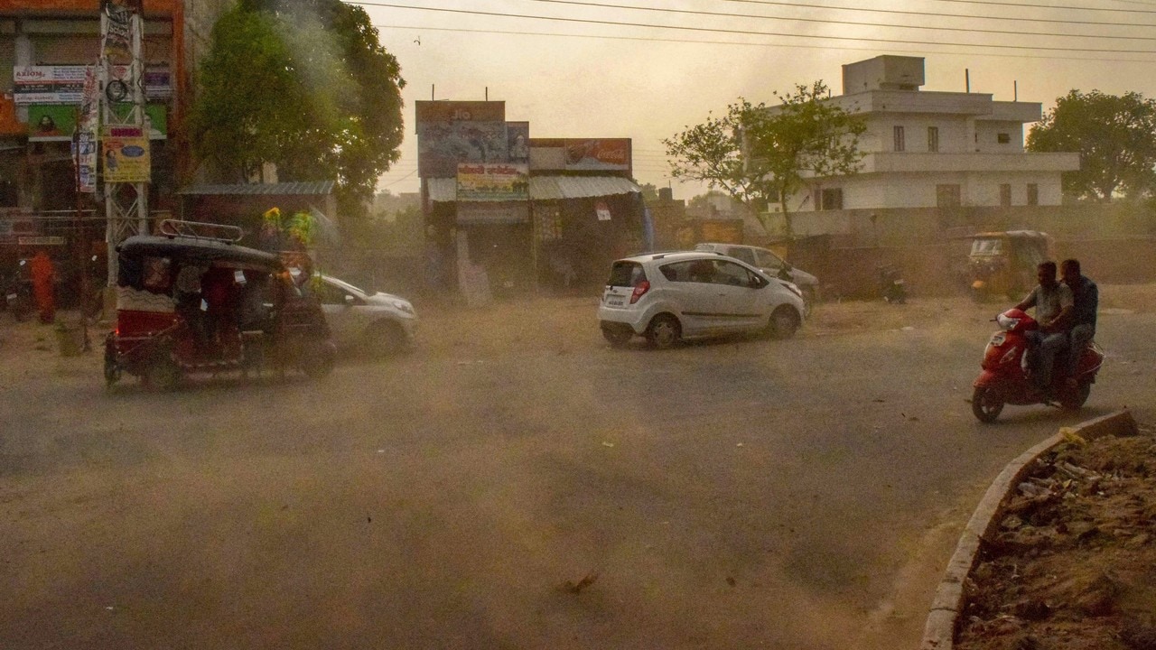 Vehicles ride past during a dust storm in Mathura on Wednesday. PTI