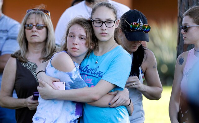 A Santa Fe High School freshman is comforted by her father during a prayer vigil following the high school shooting at Santa Fe, Texas, on Friday. AP A Santa Fe High School freshman is comforted by her father during a prayer vigil following the high school shooting at Santa Fe, Texas, on Friday. AP