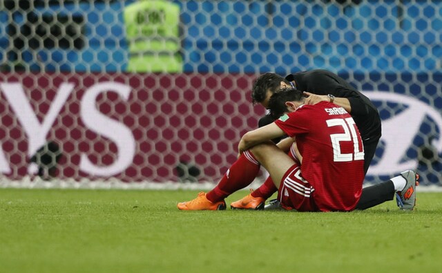 Iran's Sardar Azmoun is consoled at the end of their match against Spain, which they lost narrowly by a margin of 1-0. AP Iran's Sardar Azmoun is consoled at the end of their match against Spain, which they lost narrowly by a margin of 1-0. AP