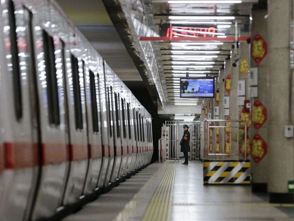 A member of the security personnel stands on duty on an empty train platform inside a station on the Subway Line Number 1 in Beijing, China, Image: Reuters