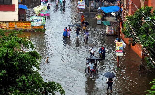 Commuters cross a waterlogged street after heavy rainfall in Kolkata on Tuesday. The city recorded a maximum rainfall of 43 millimetres in Alipore area till 5.30 pm. PTI Commuters cross a waterlogged street after heavy rainfall in Kolkata on Tuesday. The city recorded a maximum rainfall of 43 millimetres in Alipore area till 5.30 pm. PTI