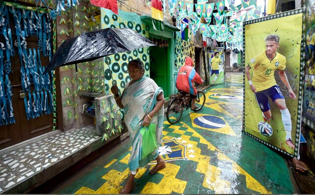 People commute on a road decorated by Brazil fans as FIFA World Cup 2018 fever grips the city, in Kolkata. PTI People commute on a road decorated by Brazil fans as FIFA World Cup 2018 fever grips the city, in Kolkata. PTI