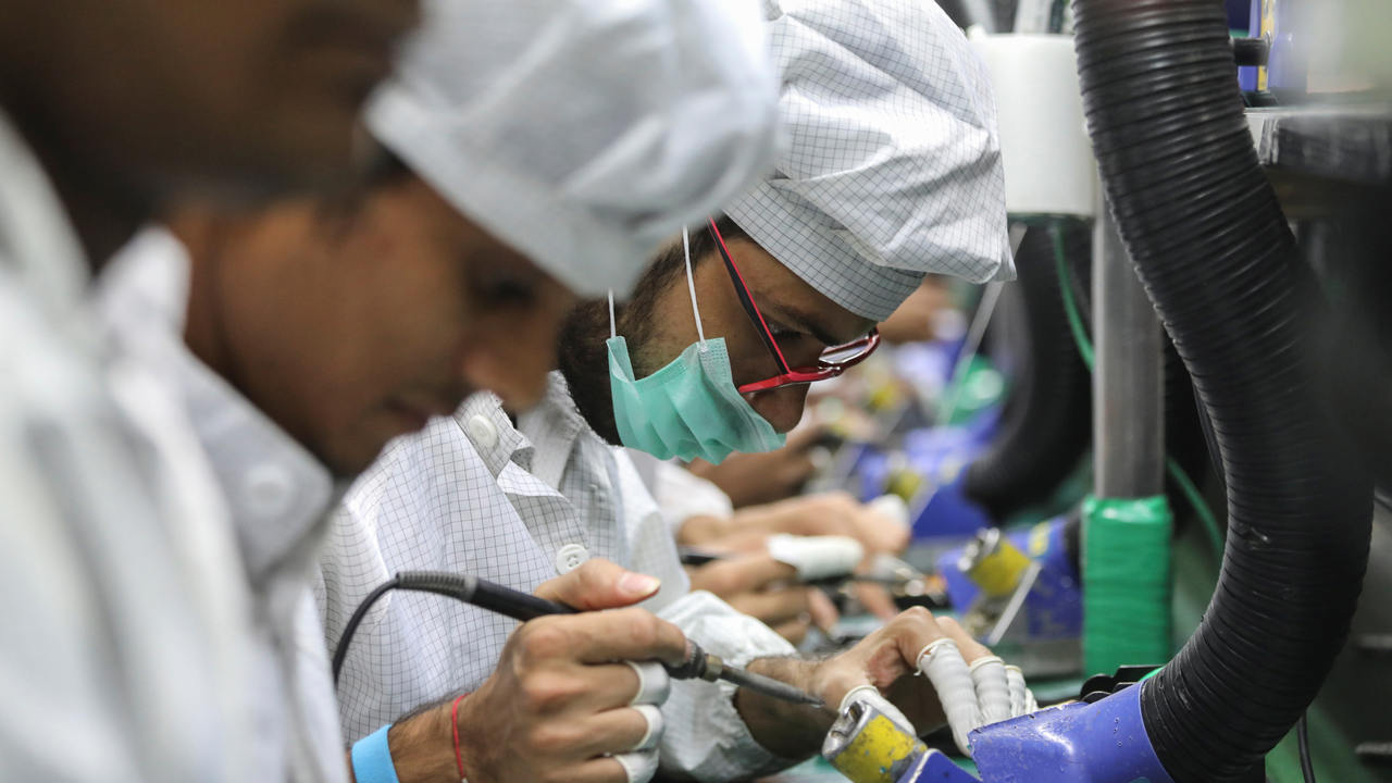 Workers solder wires on printed circuit boards of a mobile handset at Lava International Limited's manufacturing plant in Noida, India. Image: Reuters