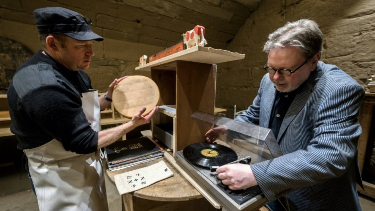 Swiss cheesemaker Wampfler (left) and director of the Music Department at University of the Arts in Bern, Michael Harenberg pose with a vynil record and wheel of Emmental. AFP