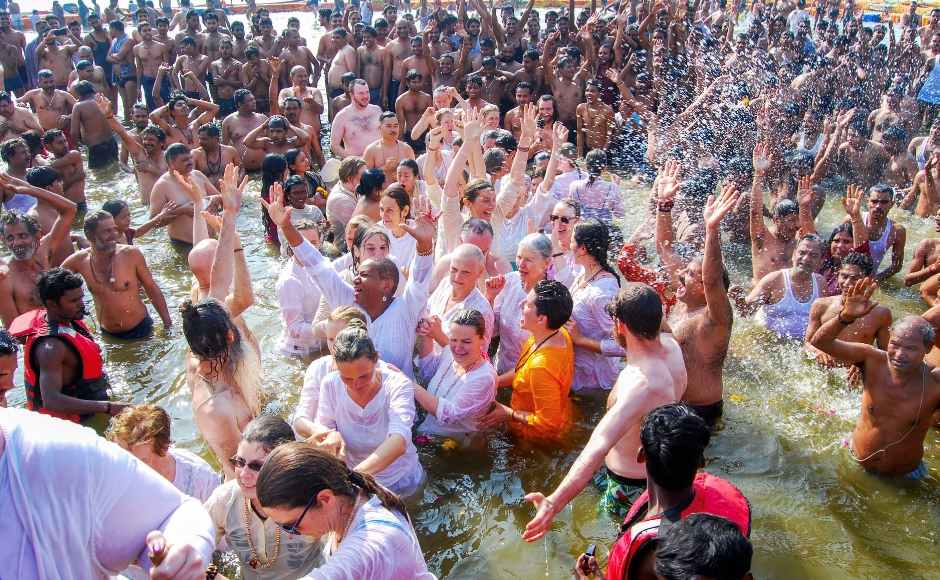 Foreign devotees take a holy dip at the Sangam. PTI Foreign devotees take a holy dip at the Sangam. PTI