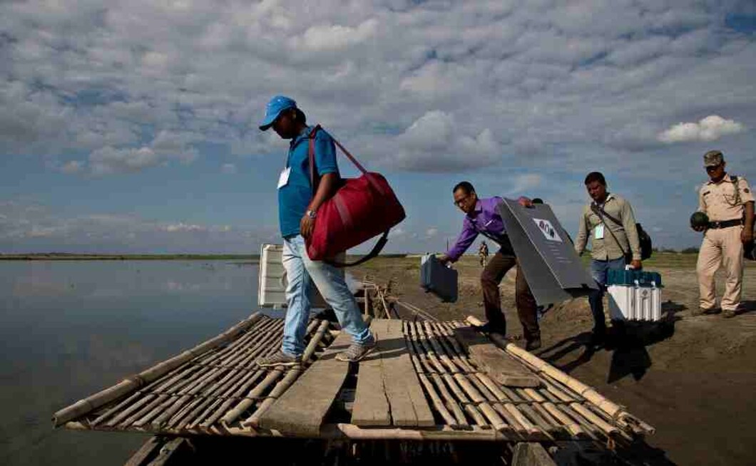 Election officials and paramilitary soldiers with election materials board on a country boat to cross the river Brahmaputra on the eve of first phase of general election in Majuli, Assam. AP Election officials and paramilitary soldiers with election materials board on a country boat to cross the river Brahmaputra on the eve of first phase of general election in Majuli, Assam. AP