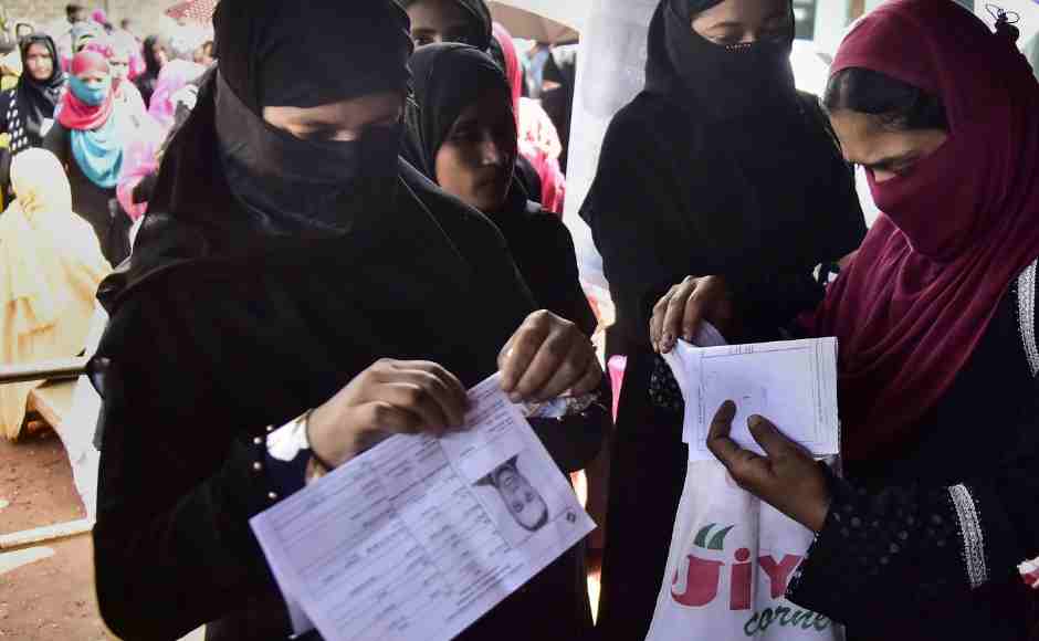 Burqa-clad women wait to cast their votes at a polling station in Hojai, Assam. PTI Burqa-clad women wait to cast their votes at a polling station in Hojai, Assam. PTI