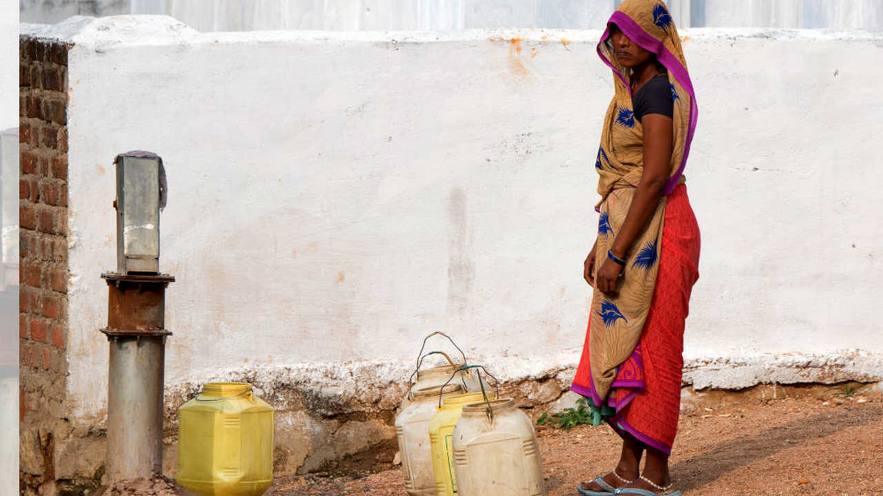 A woman filling her water cans. Image: Shutterstock