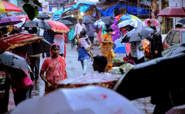 People seek shelter during sudden monsoon rainfall in Navi Mumbai on Tuesday. PTI People seek shelter during sudden monsoon rainfall in Navi Mumbai on Tuesday. PTI