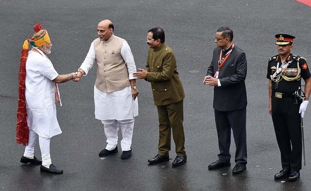 Wearing a white kurta and a colourful safa, the prime minister referred to BJP's big win in the general election to Lok Sabha and said his government's return to power showed as to how despair had given way to hope. Modi (seen here) greets Defence Minister Rajnath Singh. Image courtesy: Twitter@PIBIndia Wearing a white kurta and a colourful safa, the prime minister referred to BJP's big win in the general election to Lok Sabha and said his government's return to power showed as to how despair had given way to hope. Modi (seen here) greets Defence Minister Rajnath Singh. Image courtesy: Twitter@PIBIndia