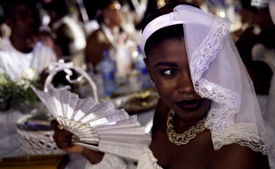 Participants set their tables, put up balloons, sparkling lights and dance to music all-night long at the event. For the 2019 edition, a performance by actor and singer, Jessie Woo, the Seester Of The House Haiti, got the crowd on its feet to 'party like Haitians' as her hit song <em>Vacation</em> suggests. Reuters/ Andres Martinez Casares Participants set their tables, put up balloons, sparkling lights and dance to music all-night long at the event. For the 2019 edition, a performance by actor and singer, Jessie Woo, the Seester Of The House Haiti, got the crowd on its feet to 'party like Haitians' as her hit song <em>Vacation</em> suggests. Reuters/ Andres Martinez Casares