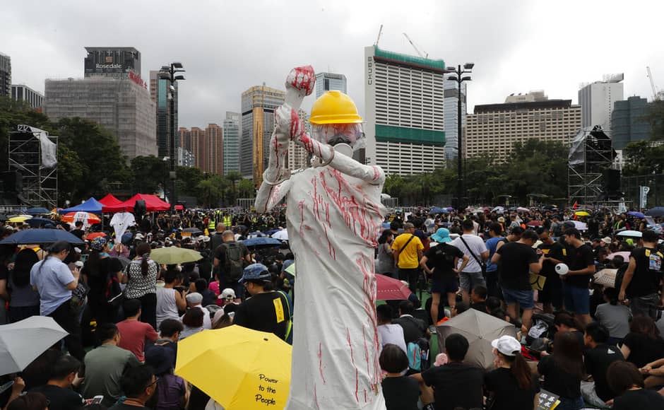 A replica of the Goddess of Democracy is displayed, wearing a hard hat, gas mask, handcuffs and covered in a red liquid during a protest rally in the Sunday rally in Hong Kong following a day of dueling rallies that highlighted the political divide in the Chinese territory. AP A replica of the Goddess of Democracy is displayed, wearing a hard hat, gas mask, handcuffs and covered in a red liquid during a protest rally in the Sunday rally in Hong Kong following a day of dueling rallies that highlighted the political divide in the Chinese territory. AP