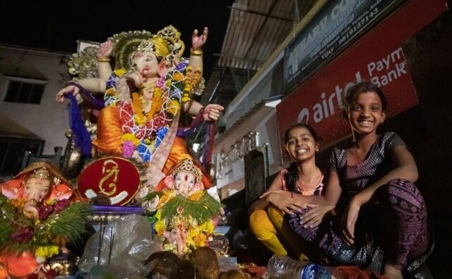 Two young girls accompany a Ganesha idol on the day of immersion. Over the 10-day period, vedic hymns are recited in the mornings and evenings in the <em>mandals</em> as well as in homes and delicious sweets, particularly the <em>modak</em>, are presented as offerings to the lord. In Mumbai, along with the small, local mandals, it is the Lalbaugcha Raja which is one of the most well-known Ganpati idols in the community. Two young girls accompany a Ganesha idol on the day of immersion. Over the 10-day period, vedic hymns are recited in the mornings and evenings in the <em>mandals</em> as well as in homes and delicious sweets, particularly the <em>modak</em>, are presented as offerings to the lord. In Mumbai, along with the small, local mandals, it is the Lalbaugcha Raja which is one of the most well-known Ganpati idols in the community.