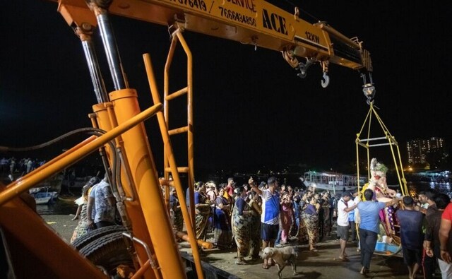A Ganpati gets carefully lowered onto a jetty with a crane, which will take Him out to sea, before being immersed into the sea water. A Ganpati gets carefully lowered onto a jetty with a crane, which will take Him out to sea, before being immersed into the sea water.