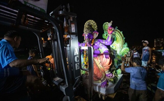 Ganesha idols are heavy structures created over months of labour. A forklift truck lifts this Ganesha onto the awaiting jetty that will take the statue out into the deeper waters for immersion. Ganesha idols are heavy structures created over months of labour. A forklift truck lifts this Ganesha onto the awaiting jetty that will take the statue out into the deeper waters for immersion.