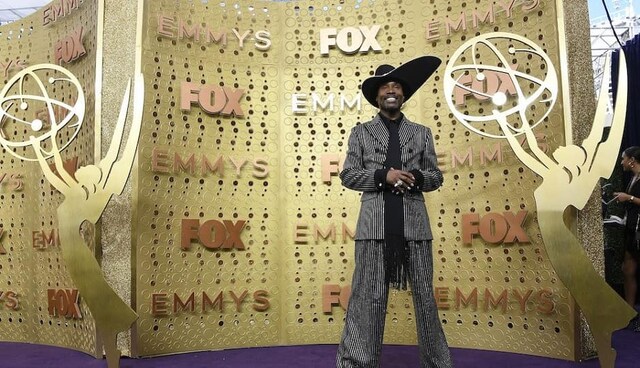 Billy Porter wears a Michael Kors Collection striped suit with a dramatic hat | Getty Images Billy Porter wears a Michael Kors Collection striped suit with a dramatic hat | Getty Images