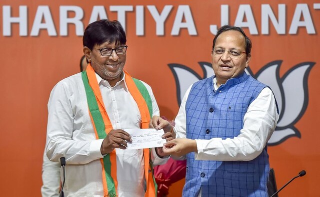 In Delhi, Senior BJP leader Arun Singh handed the party ticket to former BSP leader Kartar Singh Bhadana after the latter joined BJP at party headquarters in New Delhi. PTI In Delhi, Senior BJP leader Arun Singh handed the party ticket to former BSP leader Kartar Singh Bhadana after the latter joined BJP at party headquarters in New Delhi. PTI