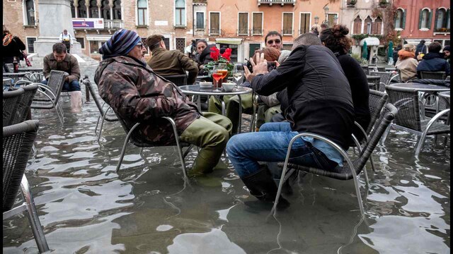 People in Venice sit outside in ankle-deep water because the entire city was flooded due to rising sea levels. Image: Flickr People in Venice sit outside in ankle-deep water because the entire city was flooded due to rising sea levels. Image: Flickr