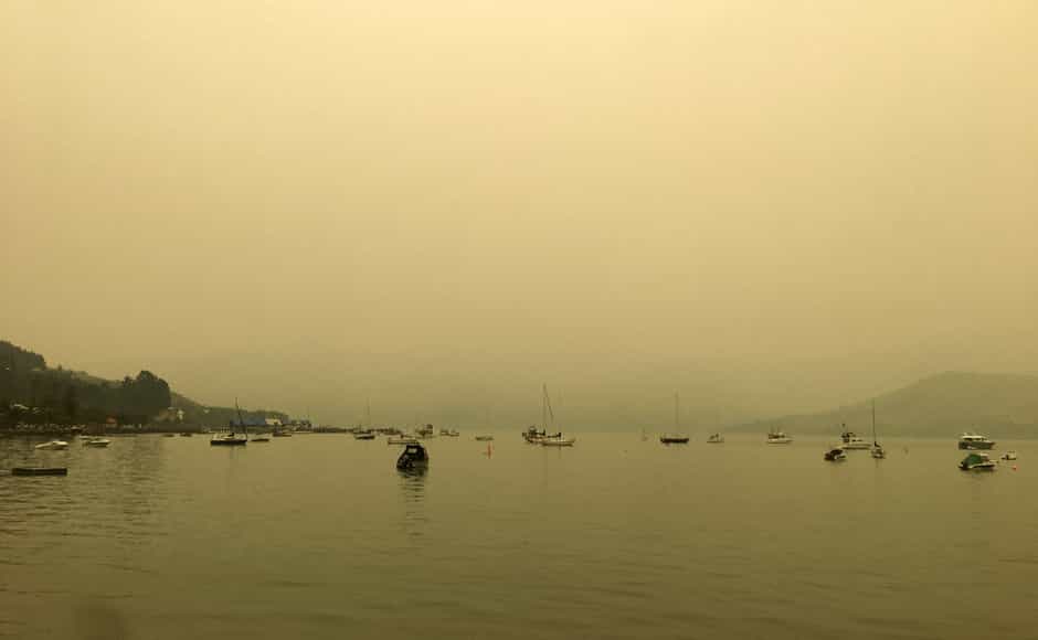 A yellow light illuminates the sky as the sun sets over Akaroa Harbor as smoke from the Australian wildfires arrives on the east coast of the South Island, New Zealand. AP A yellow light illuminates the sky as the sun sets over Akaroa Harbor as smoke from the Australian wildfires arrives on the east coast of the South Island, New Zealand. AP