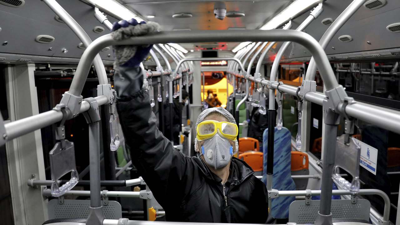 A worker disinfects a public bus against coronavirus in Tehran, Iran, in early morning. Image credit: AP