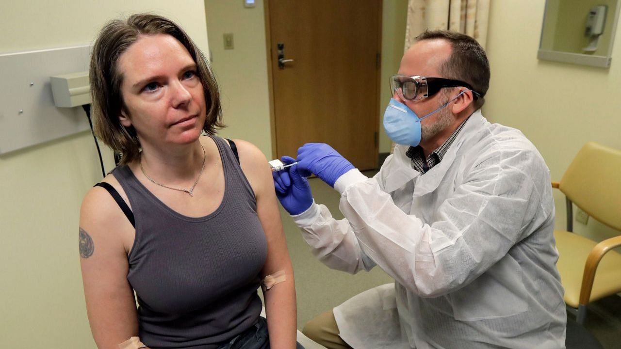 A pharmacist gives Jennifer Haller, left, the first shot in the first-stage safety study clinical trial of a potential vaccine for COVID-19. AP