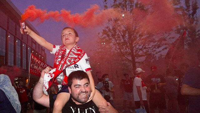 A child holds a flare in hand as fans celebrate outside Liverpool’s home ground The Anfield. AP A child holds a flare in hand as fans celebrate outside Liverpool’s home ground The Anfield. AP