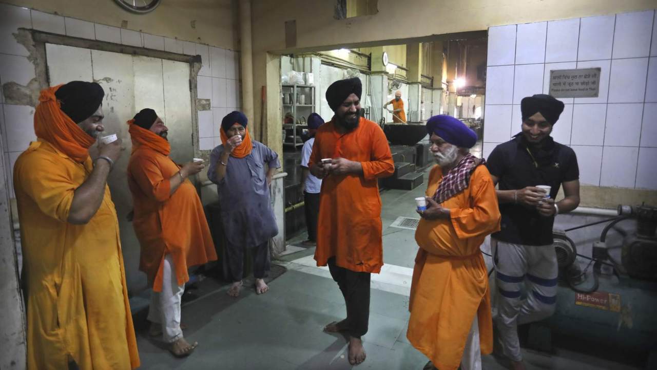 In this 10 May 2020, Sikh volunteers take a tea break in the kitchen hall of the Bangla Sahib Gurdwara in New Delhi, India. An act of generosity or self-sacrifice. A whimsical gesture to distract neighbors from anxiety or cabin fever during COVID-19 and lockdowns. Image: AP