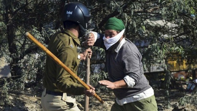 A farmer and a security person clash near Singhu Border entry point as farmers push to enter Delhi to complete the 'Delhi Chalo' march against the new farm laws. PTI A farmer and a security person clash near Singhu Border entry point as farmers push to enter Delhi to complete the 'Delhi Chalo' march against the new farm laws. PTI
