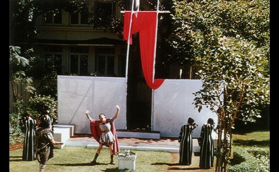 Scene from <em>Oedipus Rex</em> with Ebrahim Alkazi as Oedipus, 1954, at Bhulabhai Desai Road, Mumbai. Sophocles’ <em>Oedipus</em>, considered one of the greatest tragedies of all time, is a fast moving, almost detective-like drama. Choral speech, the stylised dance-like movement of individual actors against the mass of chorus, draped royal robes in deep rich tones, sonorous voices raised in rhythm became Alkazi’s signature style in presenting the Greeks to modern audiences. The single-storeyed Bhulabhai Desai Institute faced the Arabian Sea, with waves that furiously lashed the rocks across the road. It was here against a simple set of Greek pillars and a red drape, that Alkazi brought alive this Greek tragedy.
