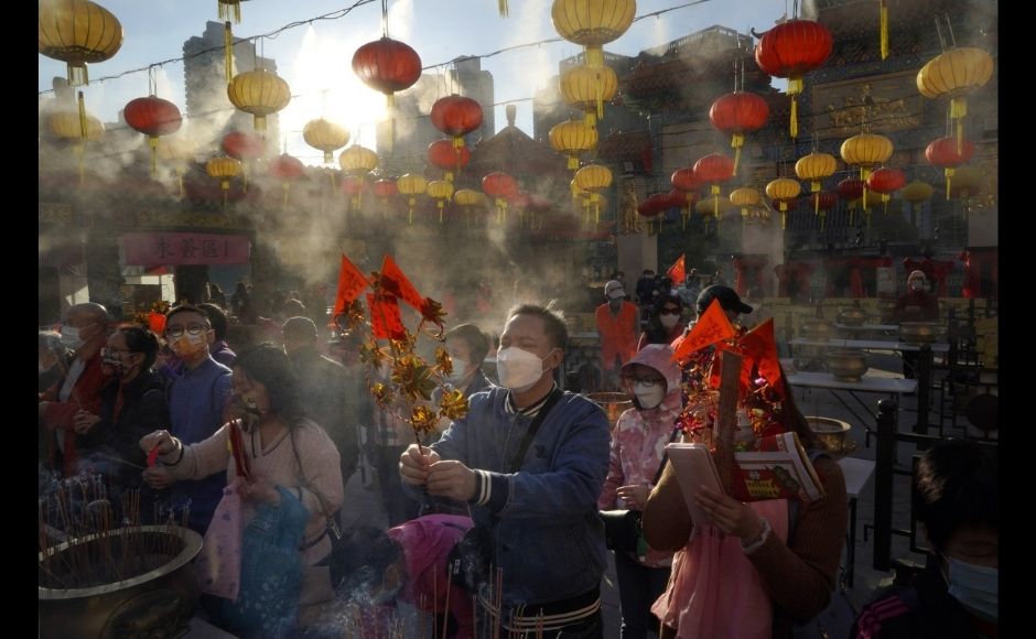 Worshippers wearing face masks to protect against the spread of the coronavirus burn joss sticks as they pray at the Wong Tai Sin Temple, in Hong Kong, Friday, 12 February, 2021, to celebrate the Lunar New Year which marks the Year of the Ox in the Chinese zodiac. Photo via The Associated Press/Kin Cheung Worshippers wearing face masks to protect against the spread of the coronavirus burn joss sticks as they pray at the Wong Tai Sin Temple, in Hong Kong, Friday, 12 February, 2021, to celebrate the Lunar New Year which marks the Year of the Ox in the Chinese zodiac. Photo via The Associated Press/Kin Cheung