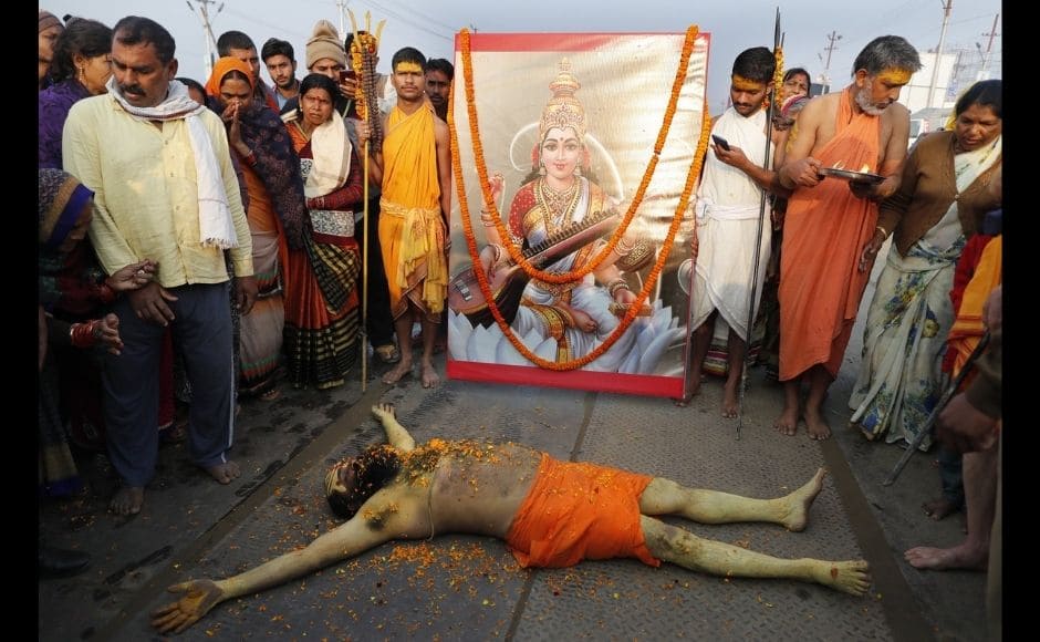 A Hindu Holy man lies in front of an image of Hindu Goddess of learning Saraswati, at Sangam, the sacred confluence of the rivers Ganga, Yamuna and the mythical Saraswati, during Magh Mela festival, in Prayagraj, India. Tuesday, 16 February, 2021. Hindus believe that ritual bathing on auspicious days can cleanse them of all sins. Photo via The Associated Press/Rajesh Kumar Singh) A Hindu Holy man lies in front of an image of Hindu Goddess of learning Saraswati, at Sangam, the sacred confluence of the rivers Ganga, Yamuna and the mythical Saraswati, during Magh Mela festival, in Prayagraj, India. Tuesday, 16 February, 2021. Hindus believe that ritual bathing on auspicious days can cleanse them of all sins. Photo via The Associated Press/Rajesh Kumar Singh)