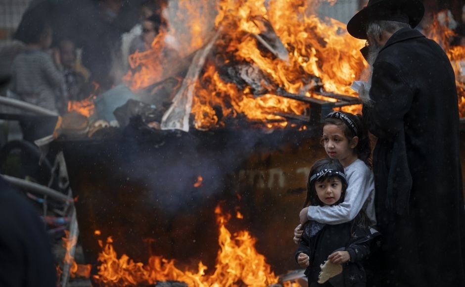 As yellow-orange flames crackle nearby, two girls embrace. One holds a piece of bread; around them, Israeli ultra-Orthodox Jews burn leavened foodstuffs that are forbidden during Passover as part of the commemoration of the Israelites’ exodus from Egypt. In the picture: Ultra-Orthodox Jewish men and children burn leavened items in final preparation for the Passover holiday in the ultra-Orthodox Jewish town of Bnei Brak, near Tel Aviv, Israel on Friday, 26 March 2021. Photo by The Associated Press/Oded Balilty As yellow-orange flames crackle nearby, two girls embrace. One holds a piece of bread; around them, Israeli ultra-Orthodox Jews burn leavened foodstuffs that are forbidden during Passover as part of the commemoration of the Israelites’ exodus from Egypt. In the picture: Ultra-Orthodox Jewish men and children burn leavened items in final preparation for the Passover holiday in the ultra-Orthodox Jewish town of Bnei Brak, near Tel Aviv, Israel on Friday, 26 March 2021. Photo by The Associated Press/Oded Balilty